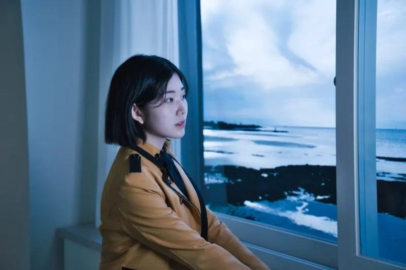 A student by the window with a seaside scene shown on the LED screen outside